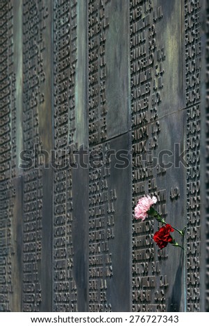 carnations on the memorial plaque fallen soldiers in World War II