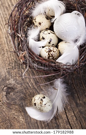 Easter eggs in a nest with white feathers , nest for easter with straw