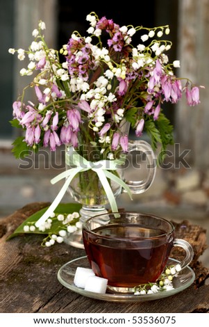 with lilies and a cup of tea and spring white and pink flowers Dicentra