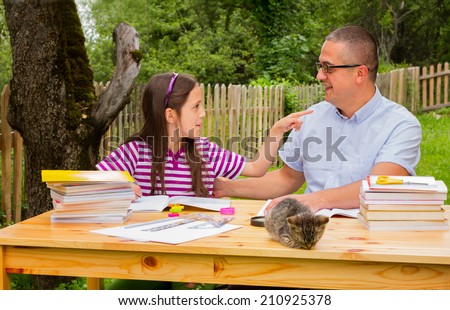 Beautiful young happy student learn outdoors with father.Beautiful young happy student learn outdoors with teacher.