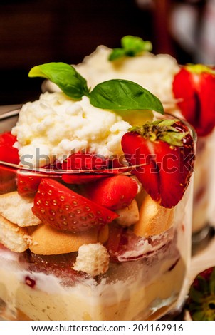 Trifle or cheesecake with strawberry on wood table