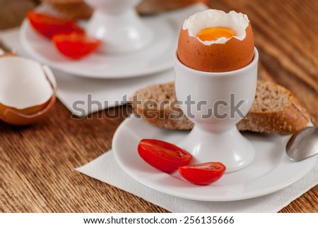 Soft boiled egg with baguette on wood table