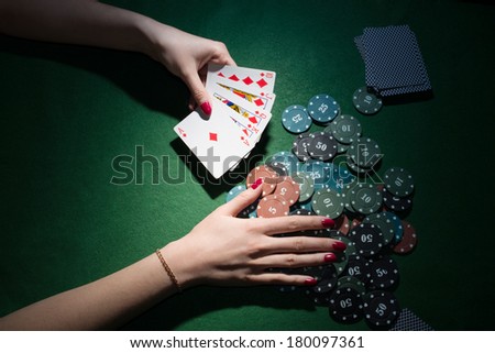 poker cards and chips in hands on green background