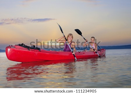 Young females kayaking on Lake Balaton at sunset