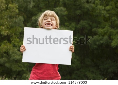 Cute girl holding a white board suitable for text.