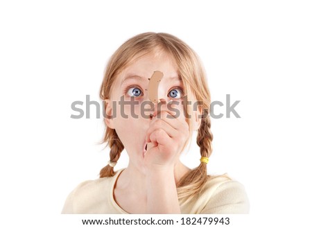 Cute girl looking at a hearing aid with wide eyes