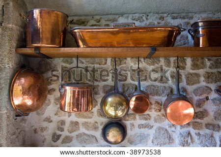 A collection of brass pots and pans in an ancient kitchen