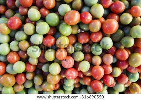 Malaysian local tomato selling at sunday market. Colorfull tomato, red tomato, green tomato, red and green tomato. Red and green tomato background. \
		Selective focus with shallow depth of field.