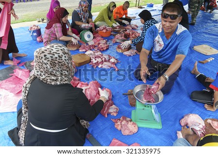 Sabah, Malaysia-September 26, 2015:Unidentified Malaysian Muslims community help in weighing meat of slaughtered halal cow during during Eid Al-Adha Al Mubarak, Feast of Sacrifice in Tawau, Sabah.