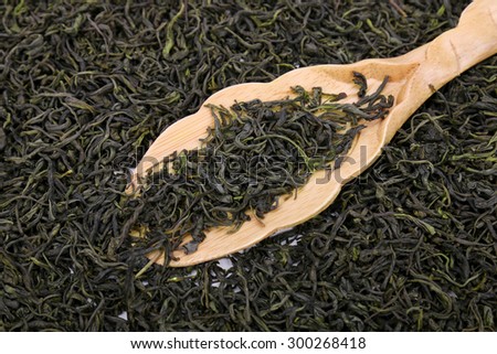 Green tea leaves full frame and wooden scoop
