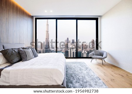 Modern and luxurious bedroom with white ceiling and wood accents with views of Burj Khalifa and downtown Dubai skyline. Condo or Hotel accomodation.