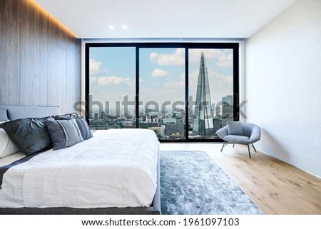 Modern and luxurious hotel bedroom with views of London skyline. Condo or 5-star upscale accommodation.