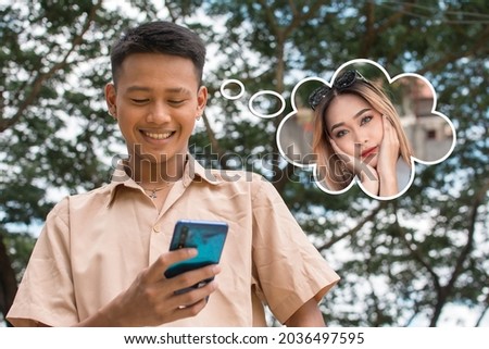 A young man happily chatting with a pretty woman he met from a dating app. Checking her profile picture. A thought bubble shows a photo of the lady. Imagine de stoc © 