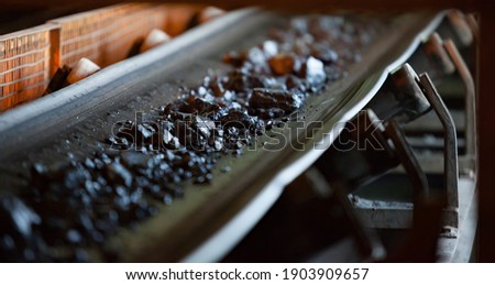 Gold ore mining and processing. Concentrating plant. Conveyor belt with gold ore rocks. Low depth-of-field. Center stones in focus Foto d'archivio © 