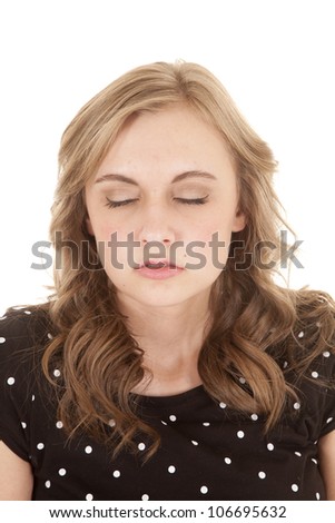 A woman in her black and white polka dot top with her eyes closed trying to remain calm