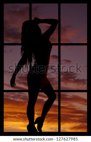 A silhouette of looking through a window at a woman in the night sky.