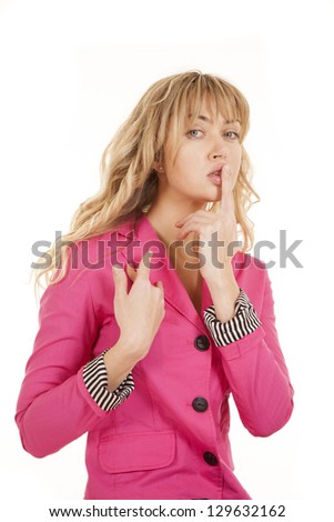 A woman with her finger up to her lips gesturing to be quiet.