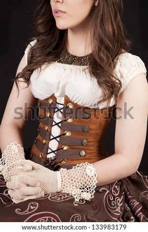 A woman sitting in her vintage clothing with her hands on her lap and only half of her face showing.