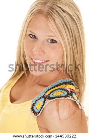 A close up of a woman with a smile on her face in her yellow tank