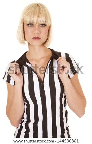 A woman referee holding on to her collar with a serious expression on her face