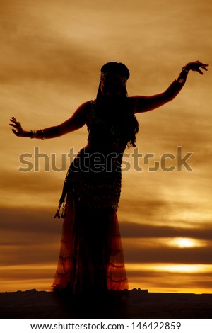 a silhouette of a woman belly dancing in the beautiful sunset