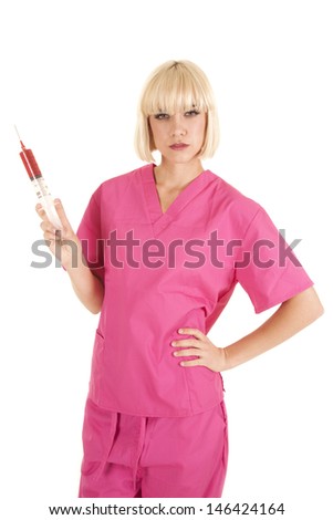 A woman nurse holding on to a red needle filled with blood with a mean expression on her face.