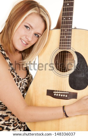 a woman leaning her head on her guitar, holding it up with a smile on her face