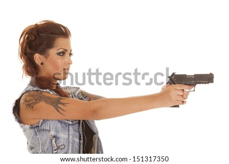 A woman with tattoos pointing a gun.