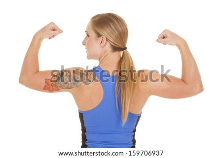 A woman looking over her shoulder while she flexes her muscles.