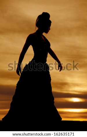 A silhouette of a woman in a dress with her hands out.