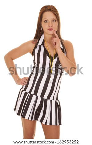 A woman referee is standing with her hand on her hip thinking.