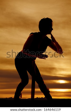A silhouette of a woman ninja ready to fight.