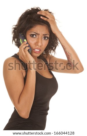 an Hispanic woman with the phone up to her ear frustrated.
