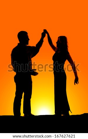 a silhouette of a man and woman dancing in the outdoors.
