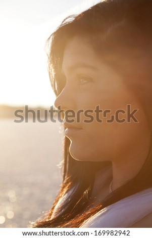 a close up of a woman\'s face in the outdoors with the frozen lake in the background.