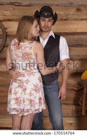 A western couple is standing in front of a wooden background.
