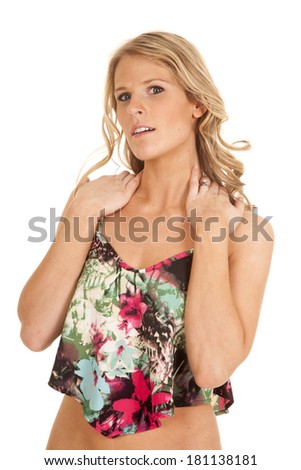 a woman with her hands on her shoulders in her crop top tank.