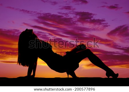 a silhouette of a woman arching her back laying back.