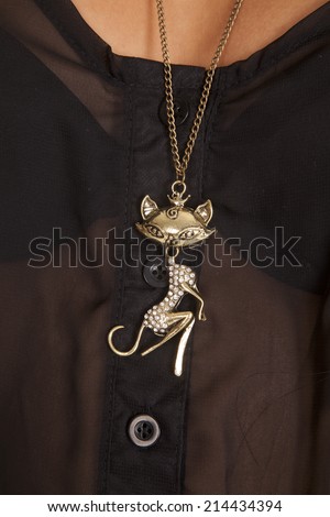 A close up of a woman wearing a cat charm necklace.