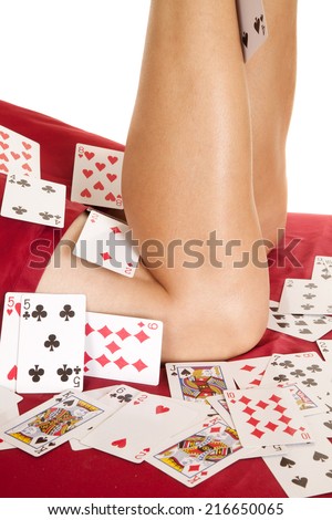 A woman with her legs up, with cards all over her legs and bed.