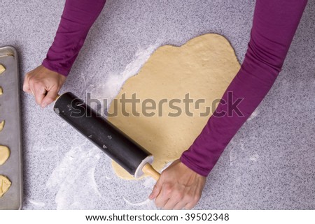 Using a rolling pin to roll out the dough.