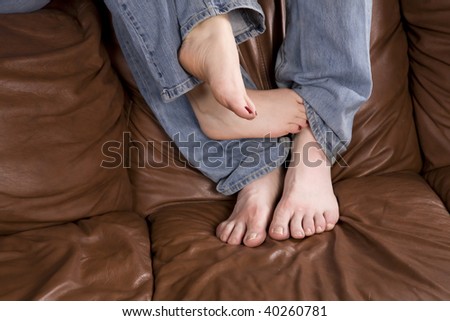 A woman playing her man\'s leg with her toes.