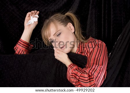 A woman laying in her bed sick and very drowsy wanting to fall asleep.