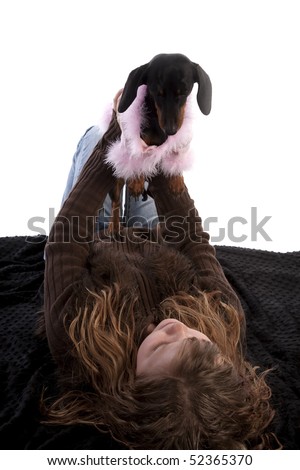 A young girl holding her dog up in the air