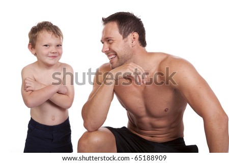 A man laughing at how his son is standing with a smirk on his face showing off their  muscles.