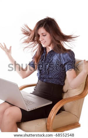 A young woman\'s hair is flying up and she is holdin a laptop with her hands thrown in the air.