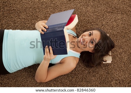A woman laying down and enjoying a good book.