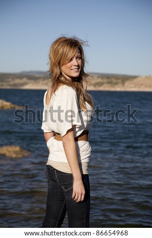 A woman looking over her shoulder looking away from the water.