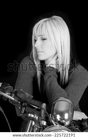 A black and white picture of a woman on a motorcycle  looking to the side.