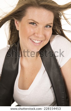 A woman in her black leather vest with the wind blowing her hair.